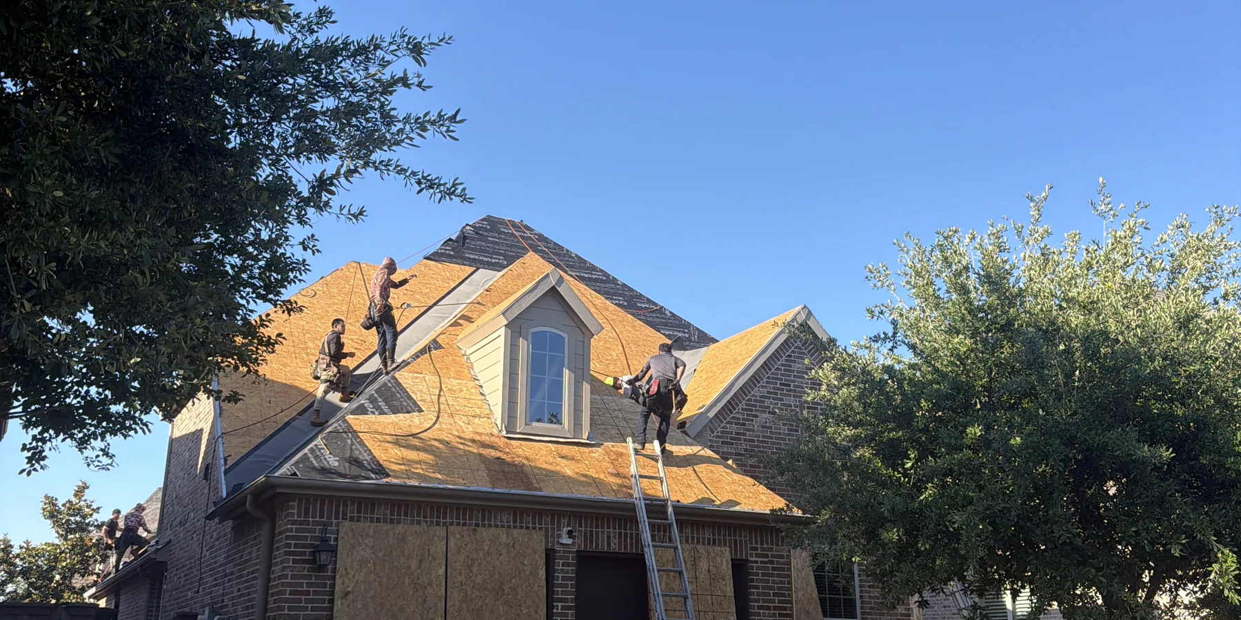 Frame Restoration roof replacement in progress in The Colony, Texas, showing exposed decking and underlayment work on a residential roof